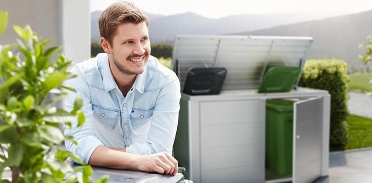 Ein Mann steht im Vorgarten und hinter ihm eine Biohort Mülltonnenbox
